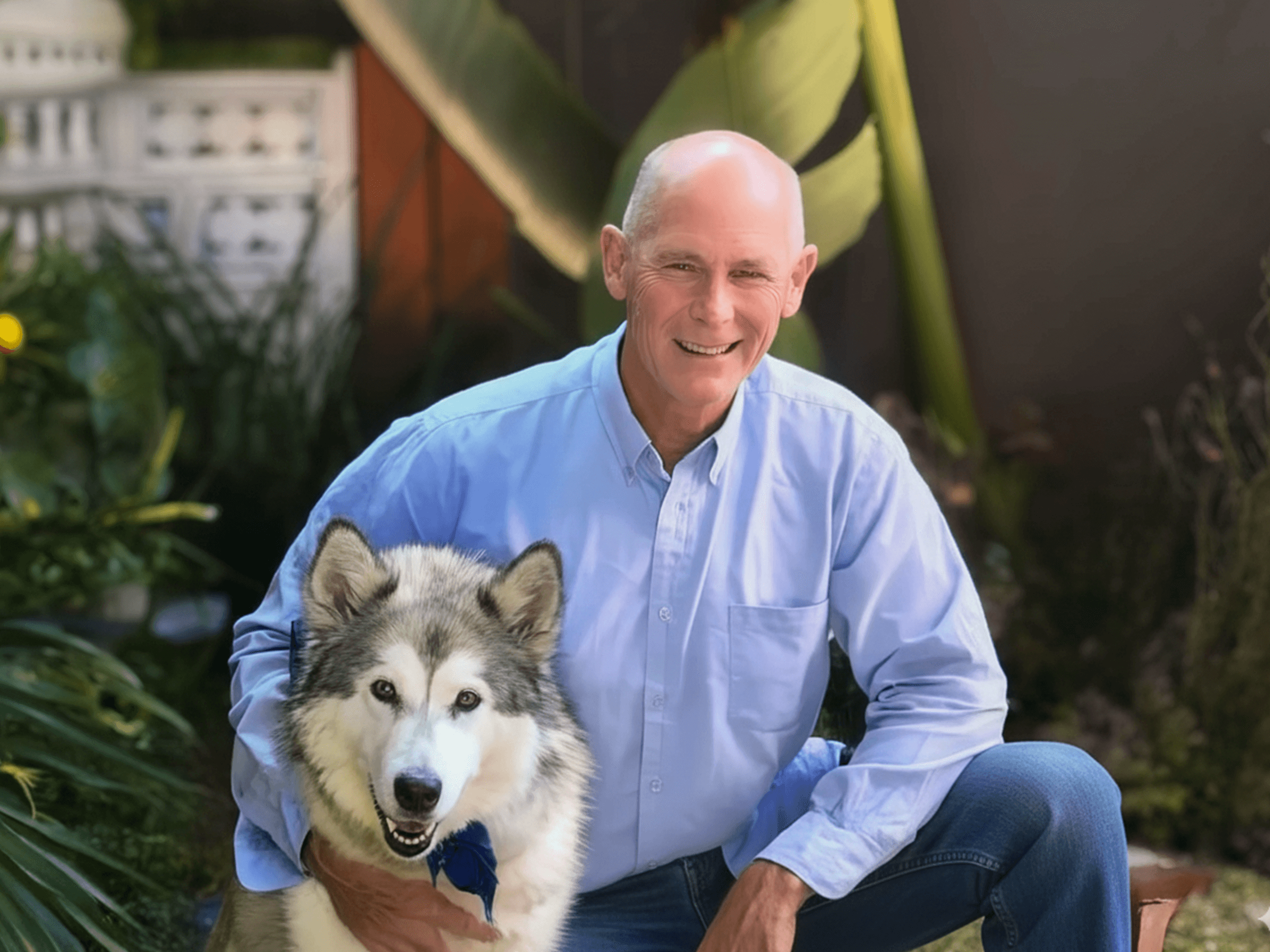 Smiling man with husky in garden